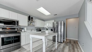 A modern kitchen with white cabinetry, stainless steel appliances, and a central island. - Georgetown Gem 💎 (Georgetown)