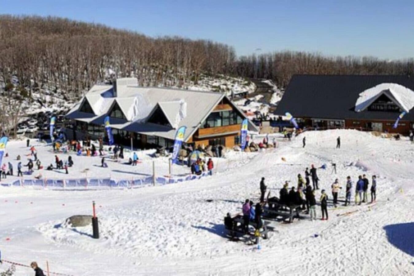 Een skigebied met gebouwen en een skipiste.