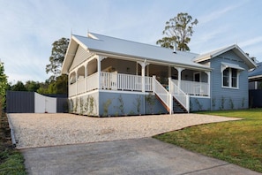 A two-story house with a covered porch and a staircase leading to the upper floor.