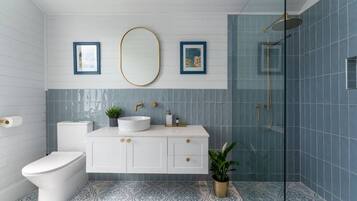 A bathroom with a toilet, sink, and shower.