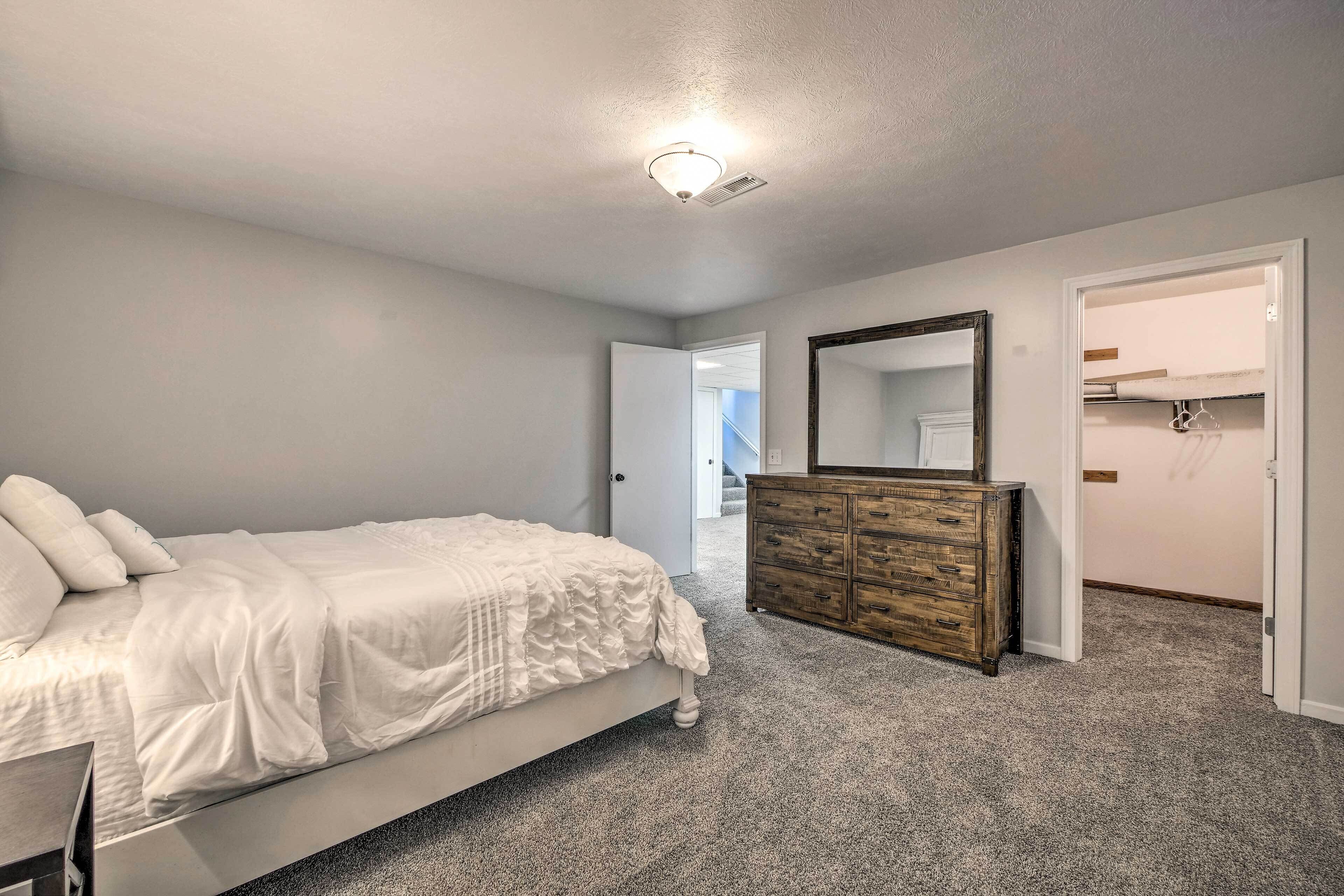 Une chambre à coucher avec un lit, une commode et un miroir.