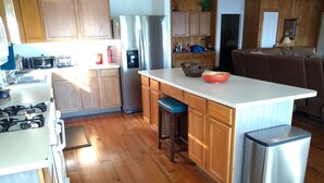 A kitchen with wooden cabinets, a stainless steel refrigerator, a gas stove, and a sink. - Parkside Perch on Lake D'Arbonne - Backup Generator and New Boat Cradle (Bernice)