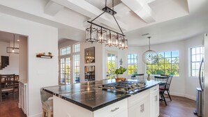 A spacious kitchen with a large island, white cabinetry, and a modern chandelier. - Custom 3,600sf Fallbrook Retreat: Wedding Guests•Family•Couples-Wine•Golf•Coast (Fallbrook)