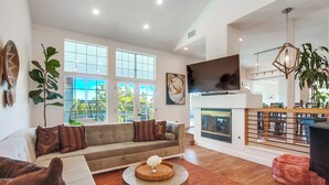 A spacious living room with a large sofa, a coffee table, and a fireplace. - Custom 3,600sf Fallbrook Retreat: Wedding Guests•Family•Couples-Wine•Golf•Coast (Fallbrook)