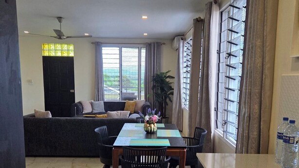 A dining area with a table, chairs, and a water dispenser. - Marigold Apartment 4.  2 bedroom 2nd floor apartment with a great view. (Nadi)