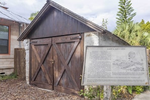 A historical building labeled 'LAST SLAVE CABIN' with a wooden exterior and a sign providing historical context.