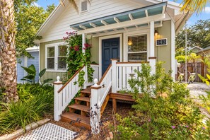 A house with a porch, a staircase, and a number 143 sign.
