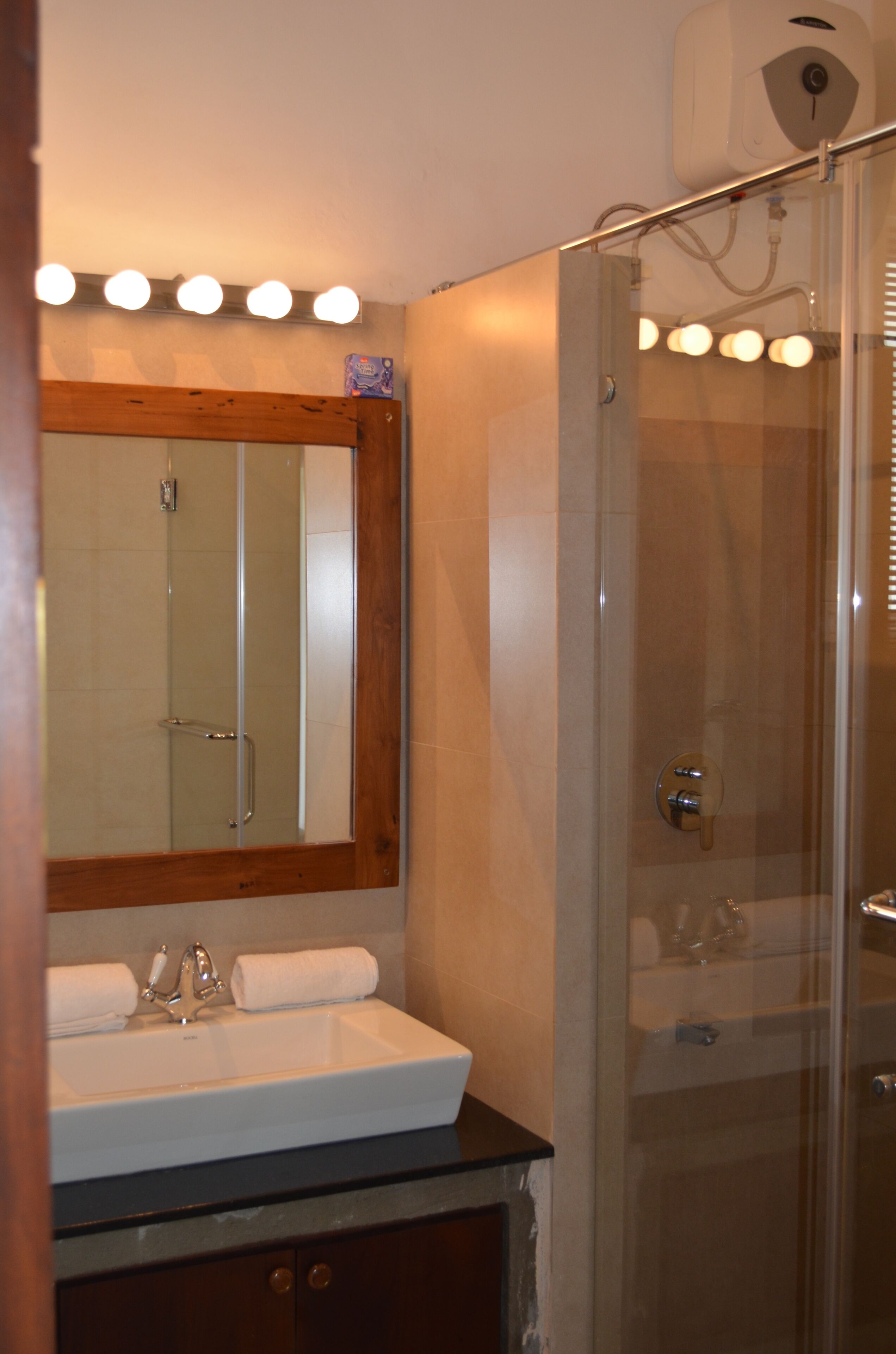 Un baño con lavamanos, espejo y ducha.
