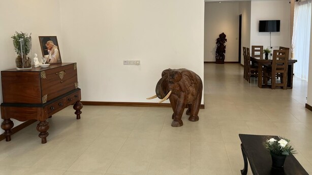 A living room with a wooden cabinet, a statue, and a large elephant sculpture. - Silina Airport Residence in Katunayake (Seeduwa - Katunayake)