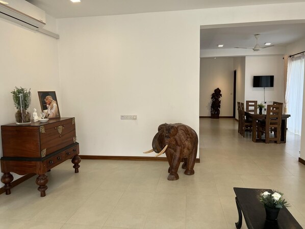 A living room with a wooden cabinet, a statue, and a large elephant sculpture.