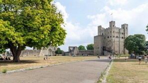 A castle with a large tree in the foreground, a paved pathway, and visitors in the background. - Captivating 2-bed Apartment in Chatham (Chatham)