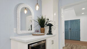 A white console table with a mirror, a potted plant, and decorative items.
