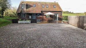 A two-story house with a gravel driveway and a patio area. - Nine Acres Barn (Marlborough)