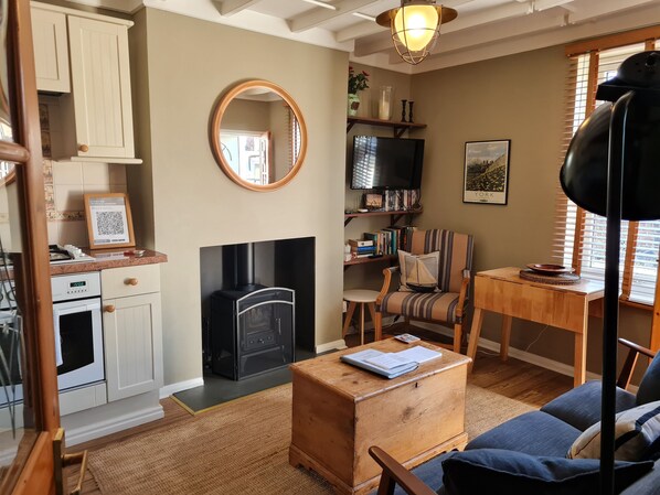 A cozy living room with a fireplace, a television, a bookshelf, and a comfortable seating area.