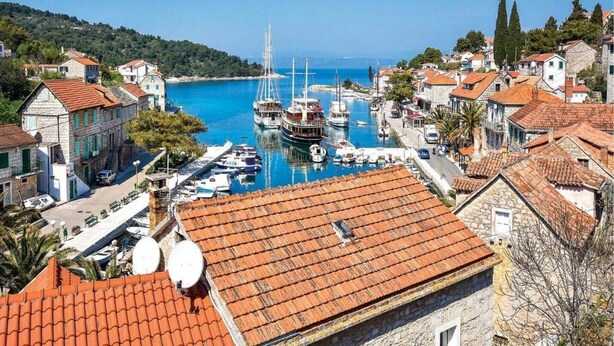 A coastal town with traditional stone buildings, a marina with boats, and a clear blue sky. - Villa Antonio - Four bedroom Villa with swimming pool (Island of Solta)