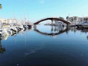 A marina with boats docked and a bridge over the water. - Little John Mobil Home (Fréjus)
