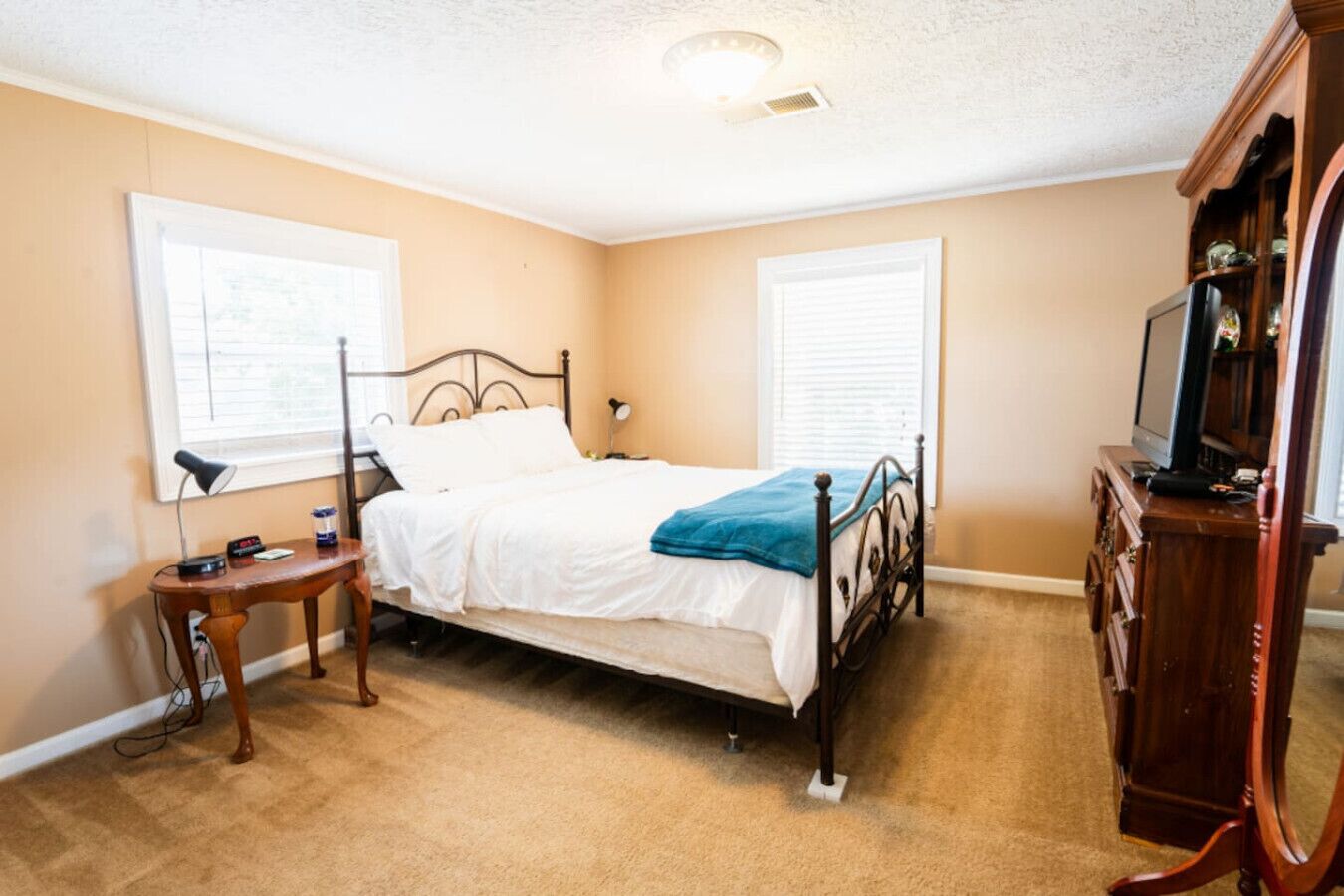 Une chambre à coucher avec un lit simple, une table de chevet, une commode et un téléviseur.