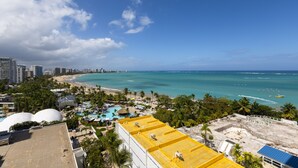 Un paysage urbain côtier avec une plage, un ciel bleu dégagé et une vue sur l’océan.