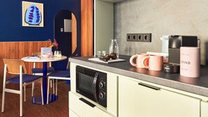 Una cocina moderna con microondas, cafetera y encimera con diversos objetos.