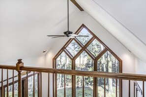 A staircase with wooden railings and a ceiling fan.