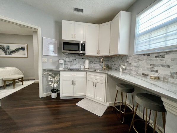 Fridge, microwave, coffee/tea maker, cookware/dishes/utensils