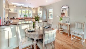 Une cuisine moderne avec un coin repas, comprenant une table ronde, des chaises et une grande fenêtre.