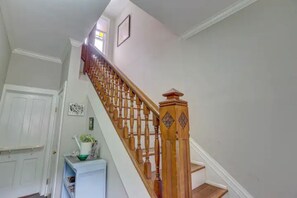 Staircase leads to an upper floor with a door and a cozy reading nook.