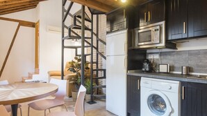 Una cucina compatta con lavatrice, forno a microonde e macchina da caffè.