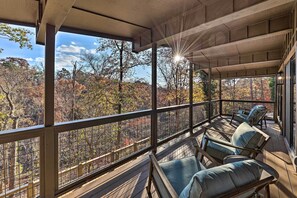 A covered outdoor seating area with a view of autumn foliage. - Hike, Bike & Unwind: Bella Vista Family Home! (Bella Vista)