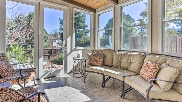 A sunroom with a sofa and chairs, large windows, and a wooden ceiling. - Near Shops & Eats! Centennial Home w/ Sunroom (Centennial)