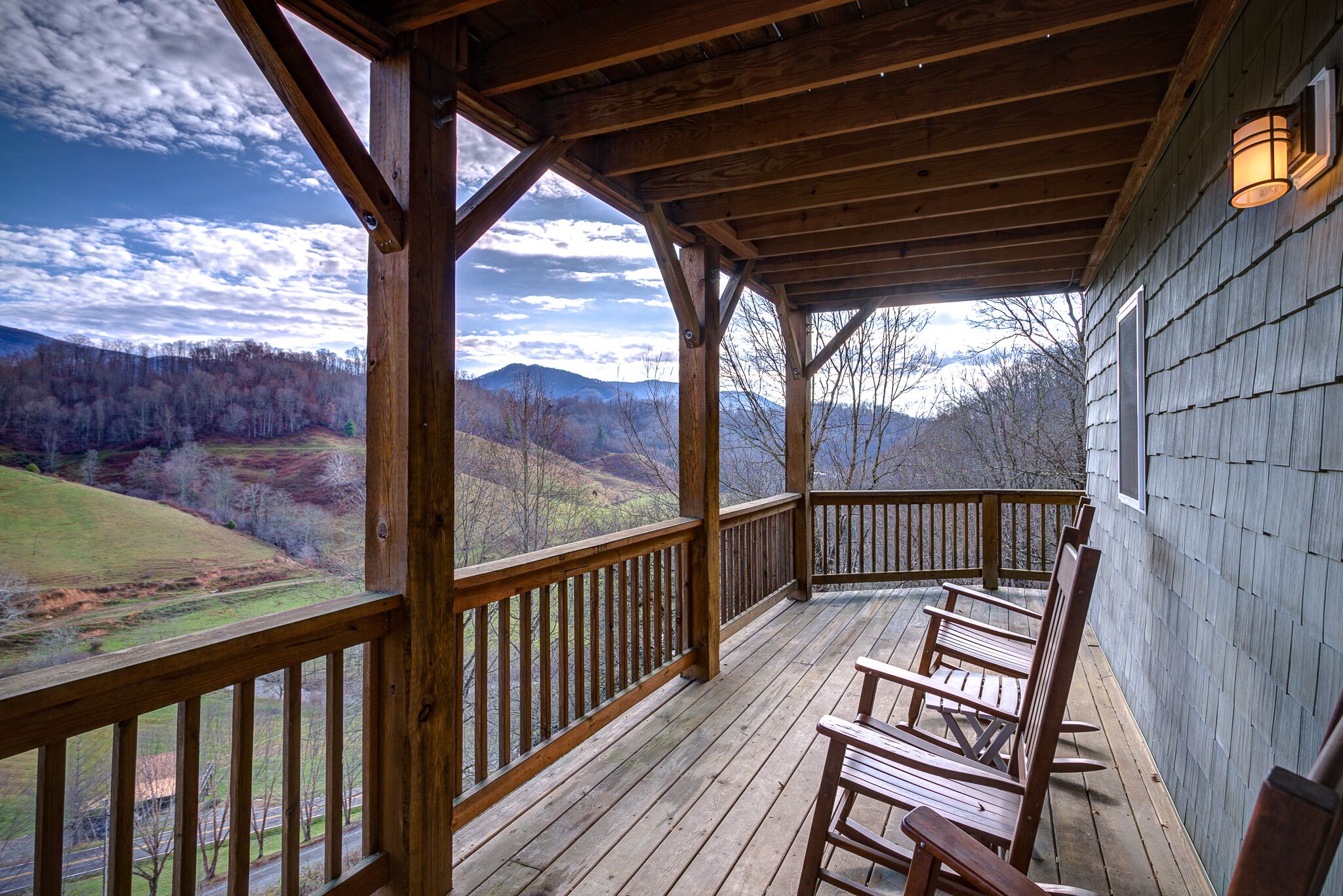 A wooden deck with a view of a hilly landscape.