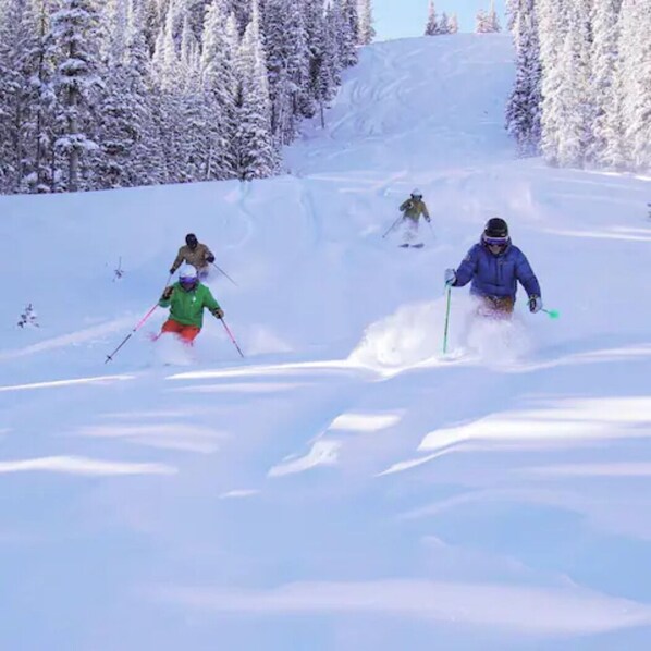 Een besneeuwde skipiste met skiërs.