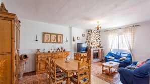 A cozy living room with a fireplace, a television, and a blue sofa. - Villa Marín Canillas de Aceituno by Ruralidays (Málaga)