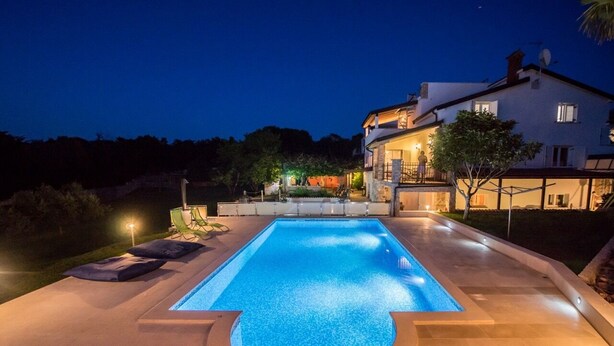 A rectangular swimming pool with a curved edge, surrounded by a paved deck. - Istrian Tavern with Shared Pool (Banjole)