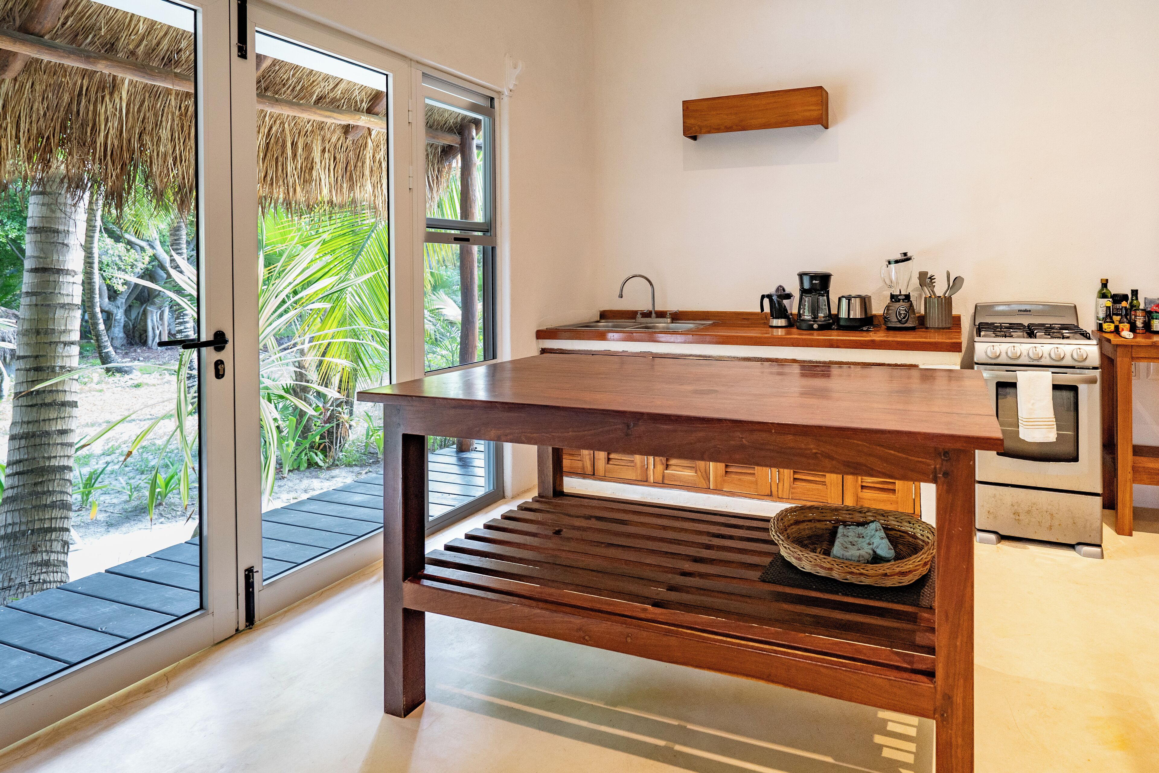 Una cocina con una mesa de madera, un fregadero y una estufa.