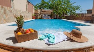 Relax by the serene pool surrounded by lush greenery and enjoy a refreshing snack from the nearby fruit basket.