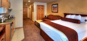 Relax in a spacious room with a large bed, kitchenette, and cozy breakfast setup.