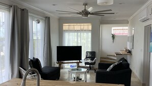 A modern kitchen with a wooden countertop, stainless steel sink, and a ceiling fan. - Ocean Front facing the Tropic of Cancer Beach !! (Little Exuma)