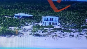 A beachfront property with a modern white building, a pool, and a clear view of the ocean. - Ocean Front facing the Tropic of Cancer Beach !! (Little Exuma)