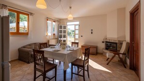 A dining area with a table set for four, a sofa, a fireplace, and a view through a glass door. - 5 bedroom lovely home in Roseto degli Abruzzi (Roseto degli Abruzzi)
