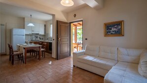 A spacious living area with a white sofa, a dining table with chairs, and a kitchen area with white cabinets and a refrigerator. - 5 bedroom lovely home in Roseto degli Abruzzi (Roseto degli Abruzzi)