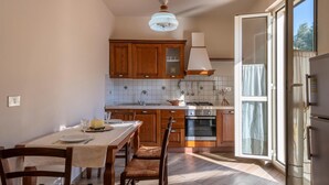 A kitchen with wooden cabinets, a dining table with chairs, a stove, and a refrigerator. - 5 bedroom lovely home in Roseto degli Abruzzi (Roseto degli Abruzzi)