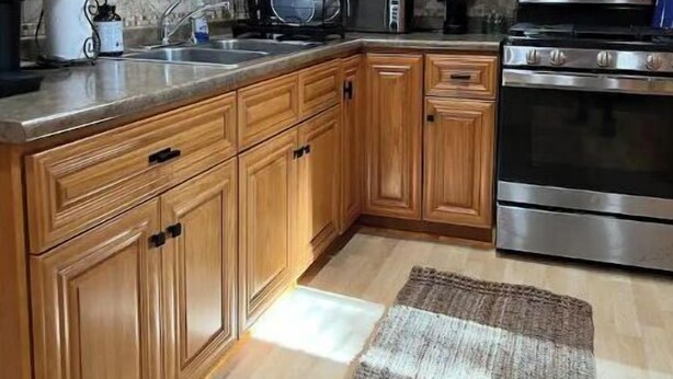 A kitchen with wooden cabinets, a microwave, an oven, and a coffee maker.