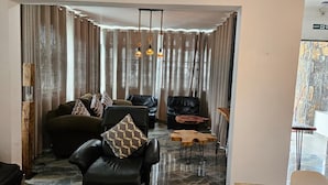 A modern living room with a leather sofa, a wooden coffee table, and a stone accent wall. - Spacious Private Villa With Roof top bar (Flic-en-Flac)