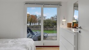 A bedroom with a bed, a window, and a view of the outdoors. - 3 bedroom beautiful home in Gudhjem (Gudhjem)