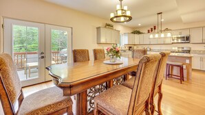A spacious kitchen with a large dining table, chairs, and a chandelier. - 2 Mi to Dtwn Colorado Springs: Home w/ Large Yard! (Colorado Springs)