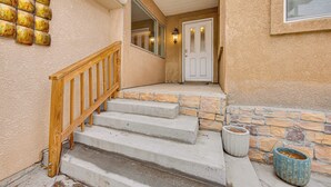 A staircase leading to a door with a stone wall and a wooden railing. - Family-Friendly Home 2 Mi to Dtwn Colorado Springs (Colorado Springs)