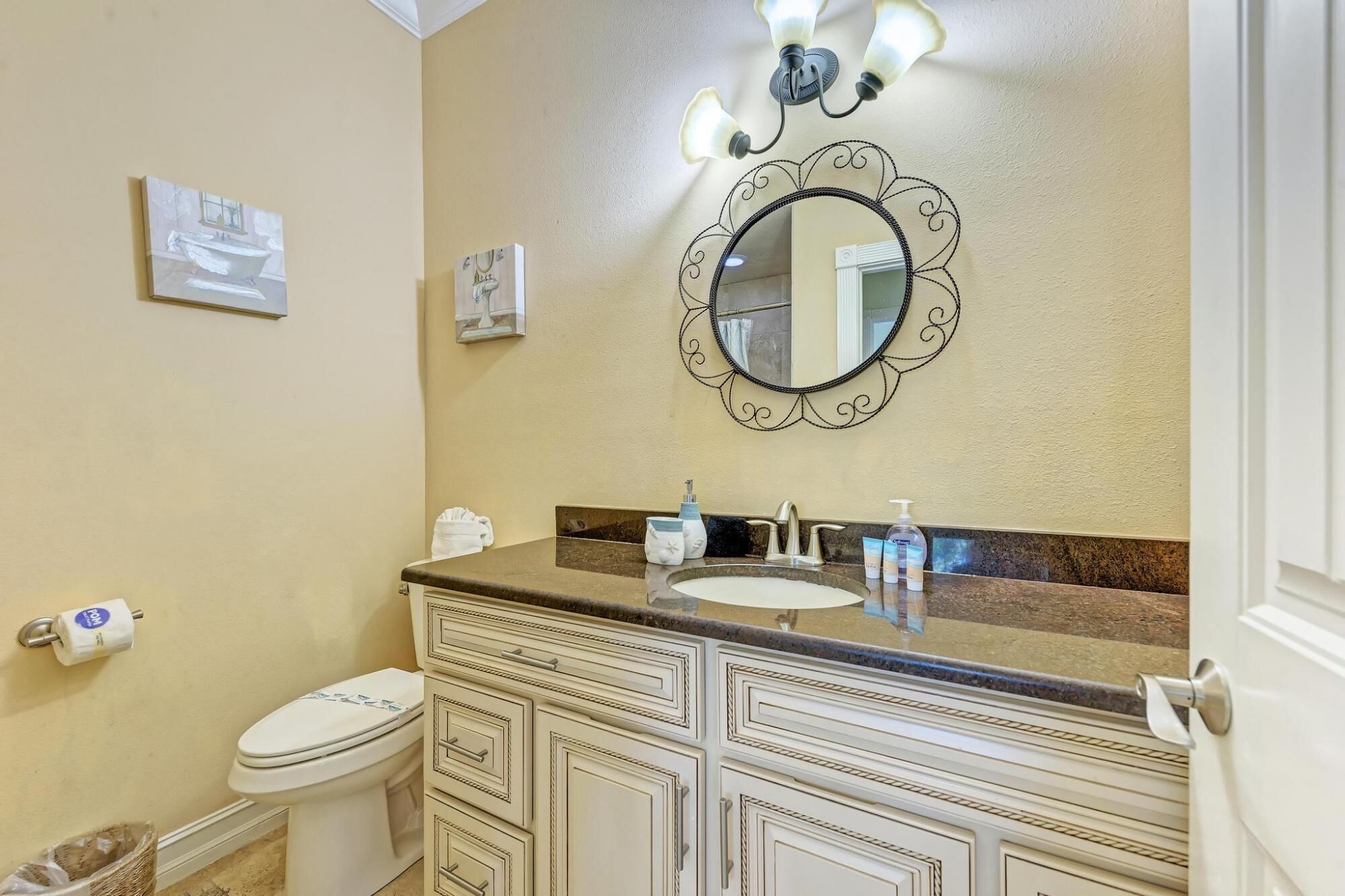 Casa de banho com lavatório, toucador, sanita e espelho com luzes decorativas.