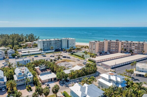 Zona hotelera costera con varios edificios, incluyendo un hotel grande de varios pisos y una edificación más pequeña con techo plano.