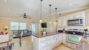 A spacious kitchen with white cabinetry, a central island, and a large oven.